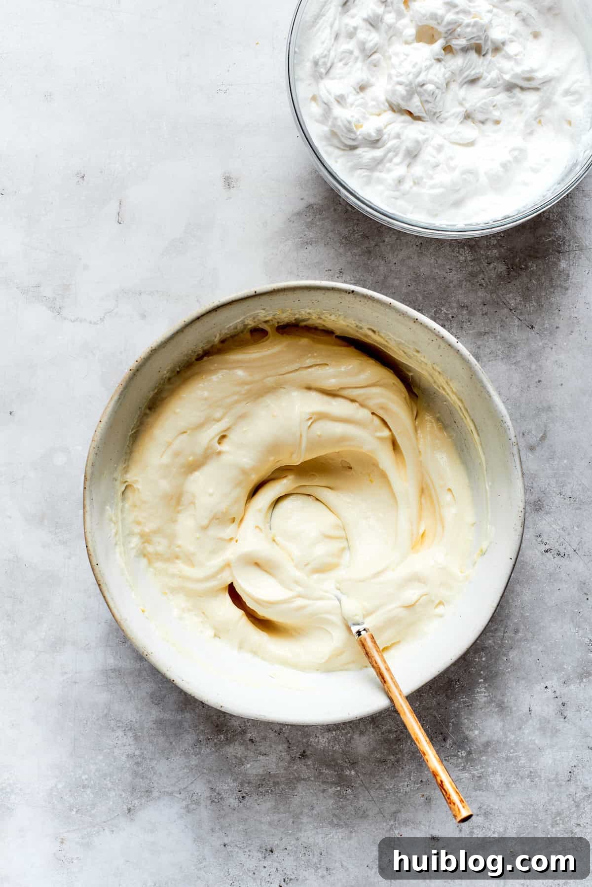 The mascarpone cheese, sugar, vanilla, and lemon zest are being mixed together until smooth and creamy for the tiramisu filling.