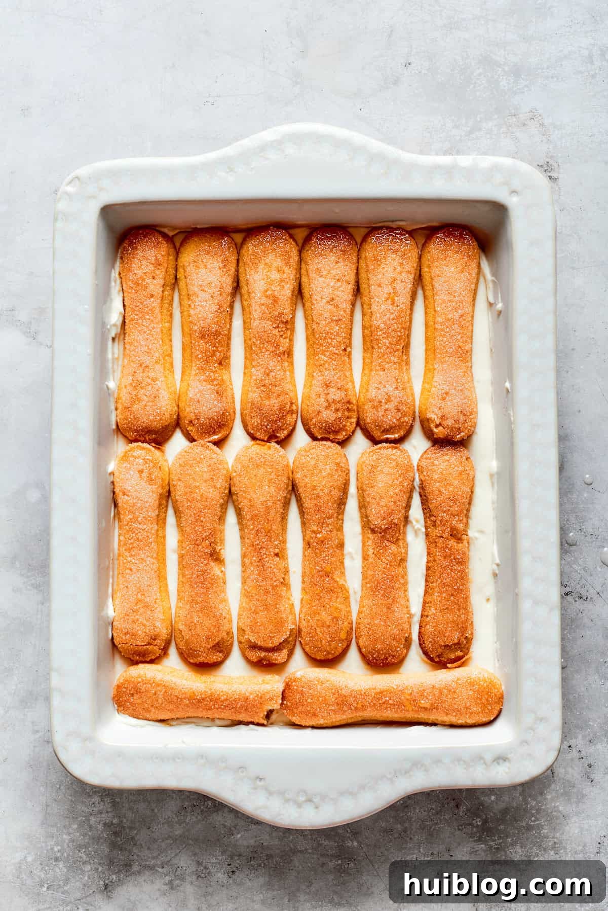 Another layer of lemon syrup-soaked ladyfinger cookies carefully placed on top of the mascarpone cream.
