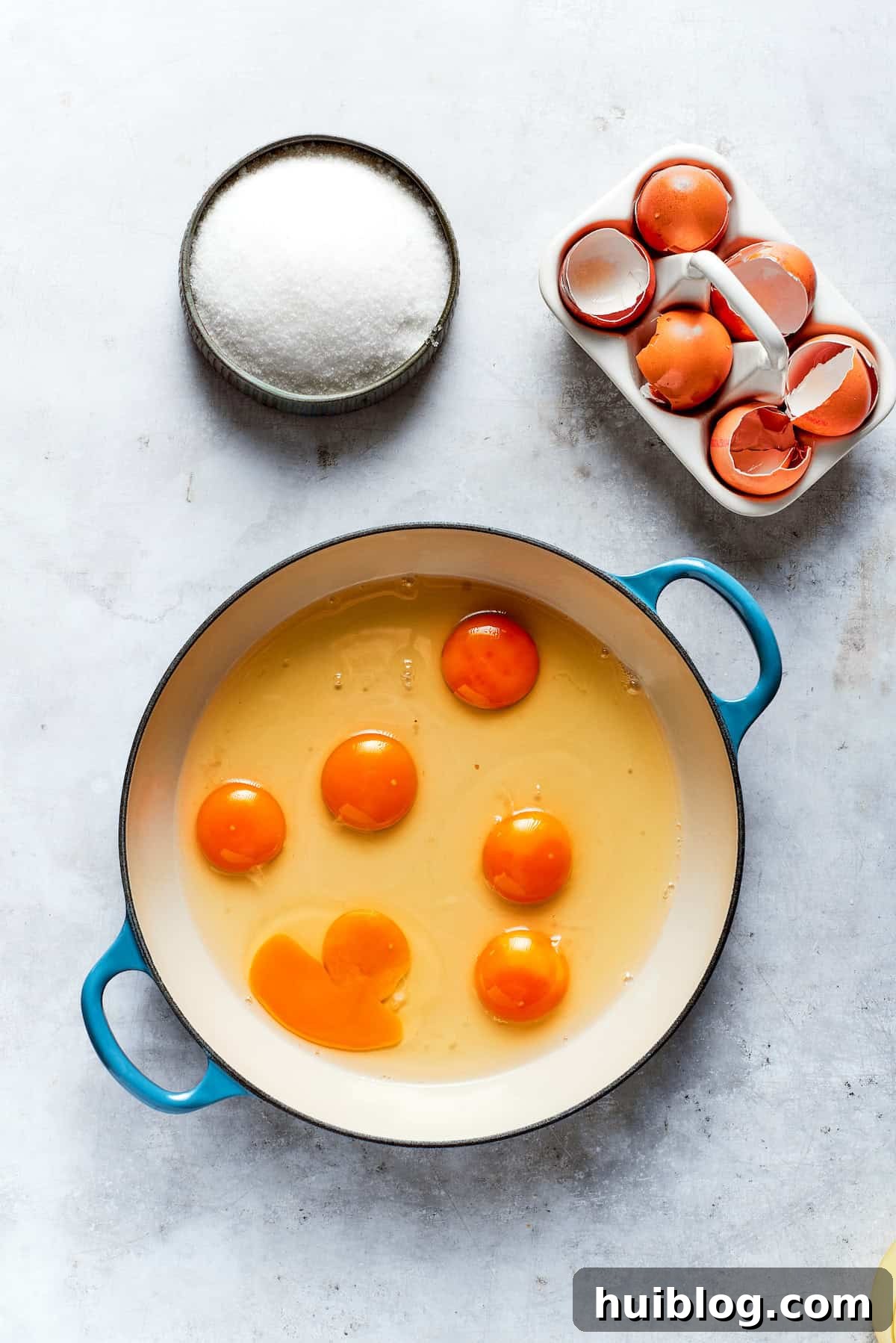 Fresh eggs are being carefully added to a pot, ready for whisking to make the lemon curd.