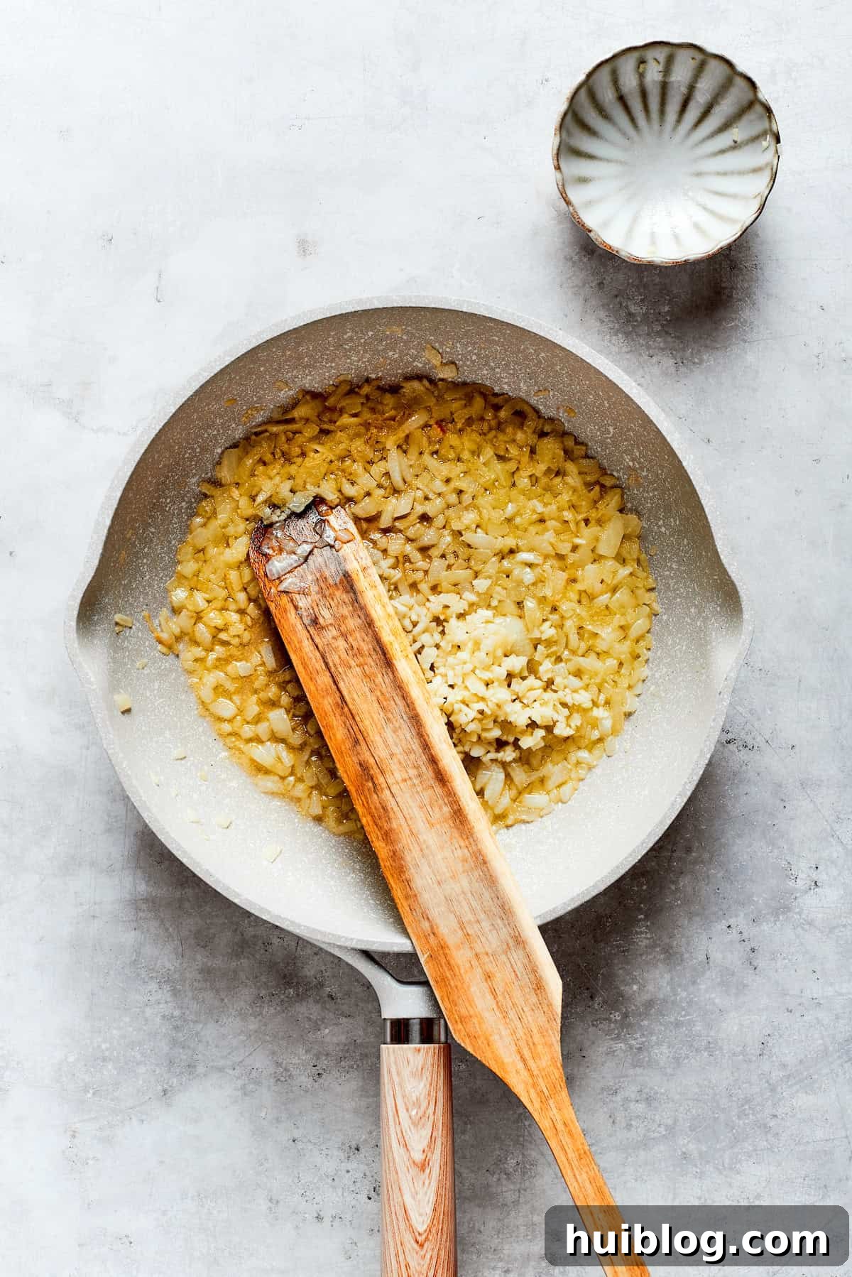 From-scratch Broccoli & Rice Casserole folds tender broccoli and fluffy white rice into a gorgeously creamy three-cheese sauce. Sautéing diced onions and minced garlic in melted butter within a large skillet, creating an aromatic base for the creamy cheese sauce.