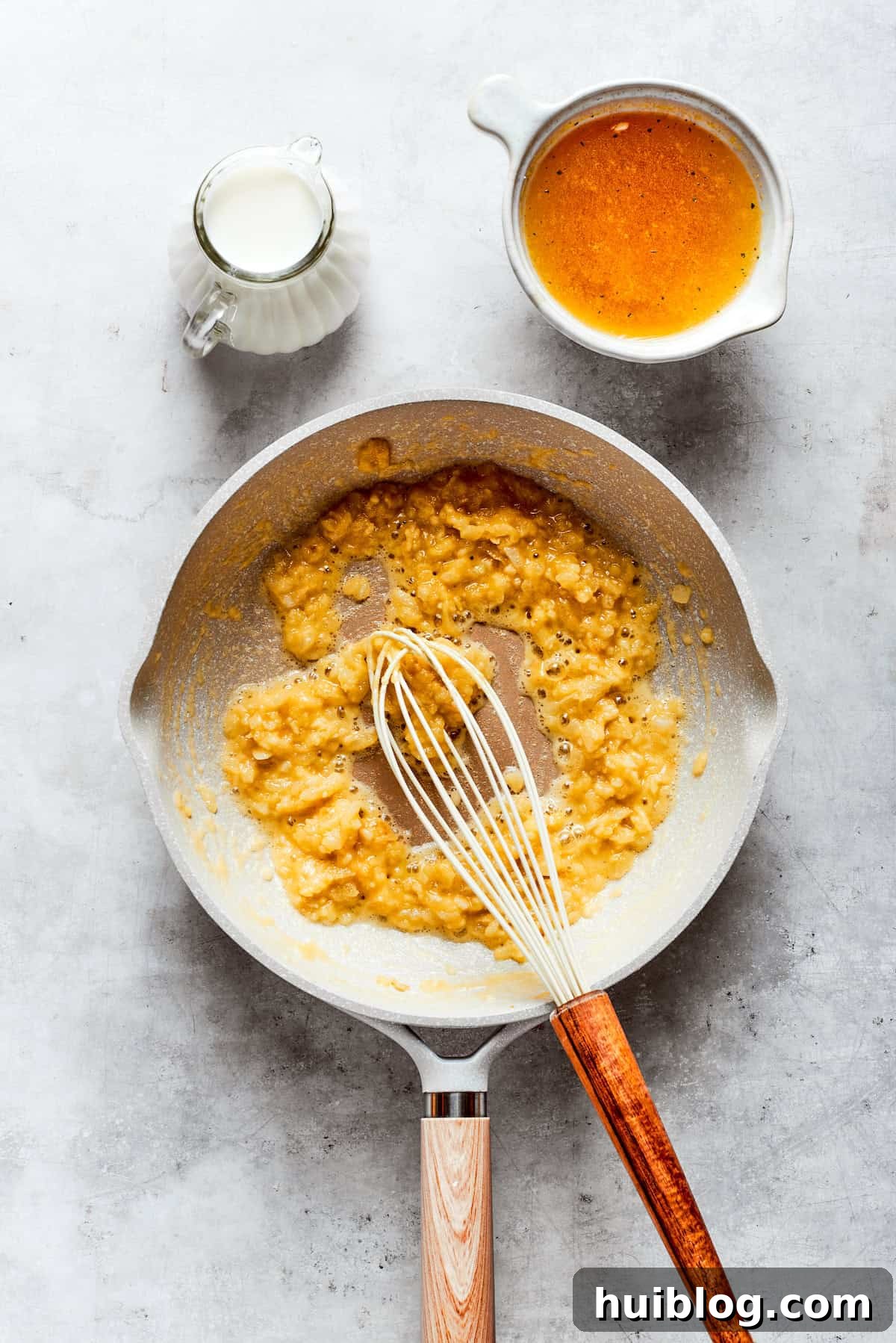 From-scratch Broccoli & Rice Casserole folds tender broccoli and fluffy white rice into a gorgeously creamy three-cheese sauce. Whisking shredded cheddar cheese into a golden roux, gradually creating the smooth, rich foundation of the casserole's creamy sauce.