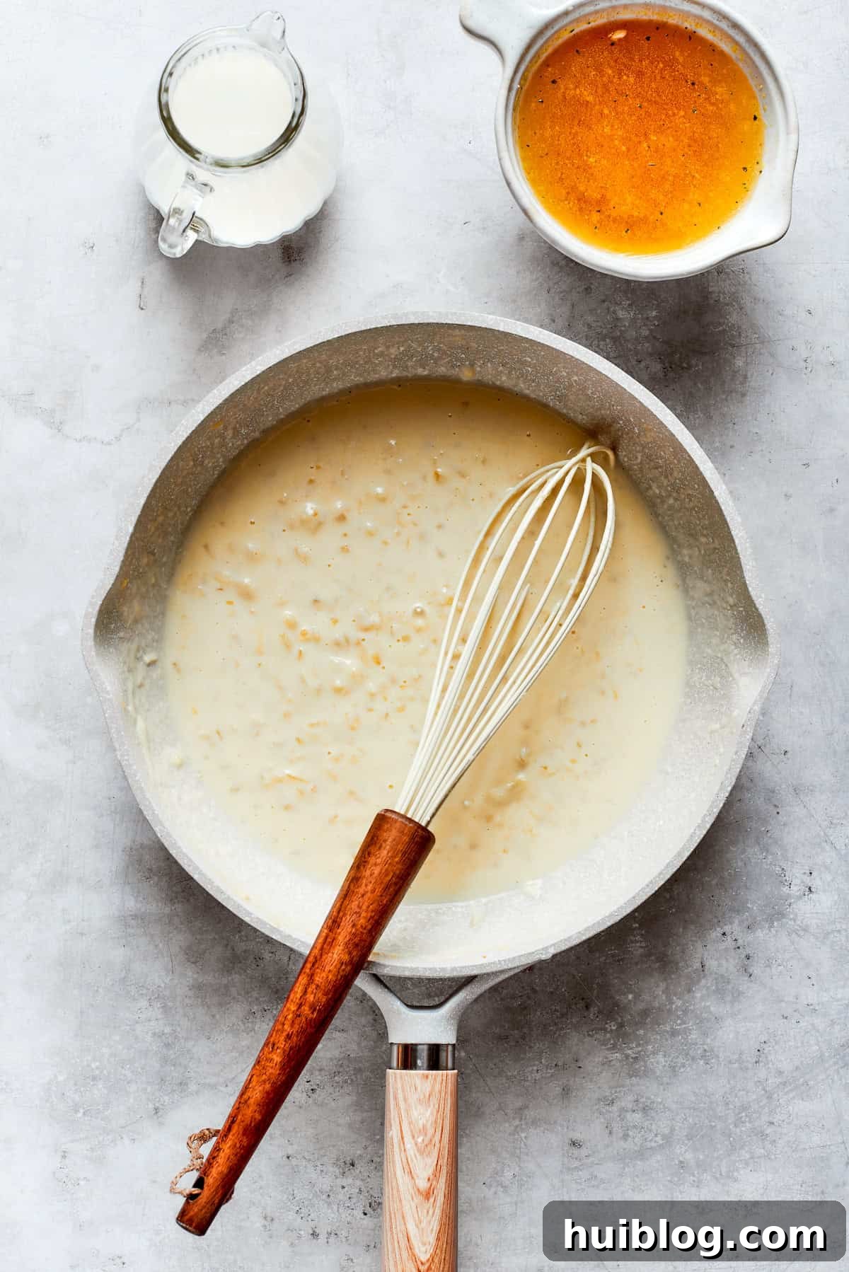 From-scratch Broccoli & Rice Casserole folds tender broccoli and fluffy white rice into a gorgeously creamy three-cheese sauce. The cheese sauce is continuously whisked in a pot over low heat, ensuring a perfectly smooth and lump-free consistency as the cheeses melt.