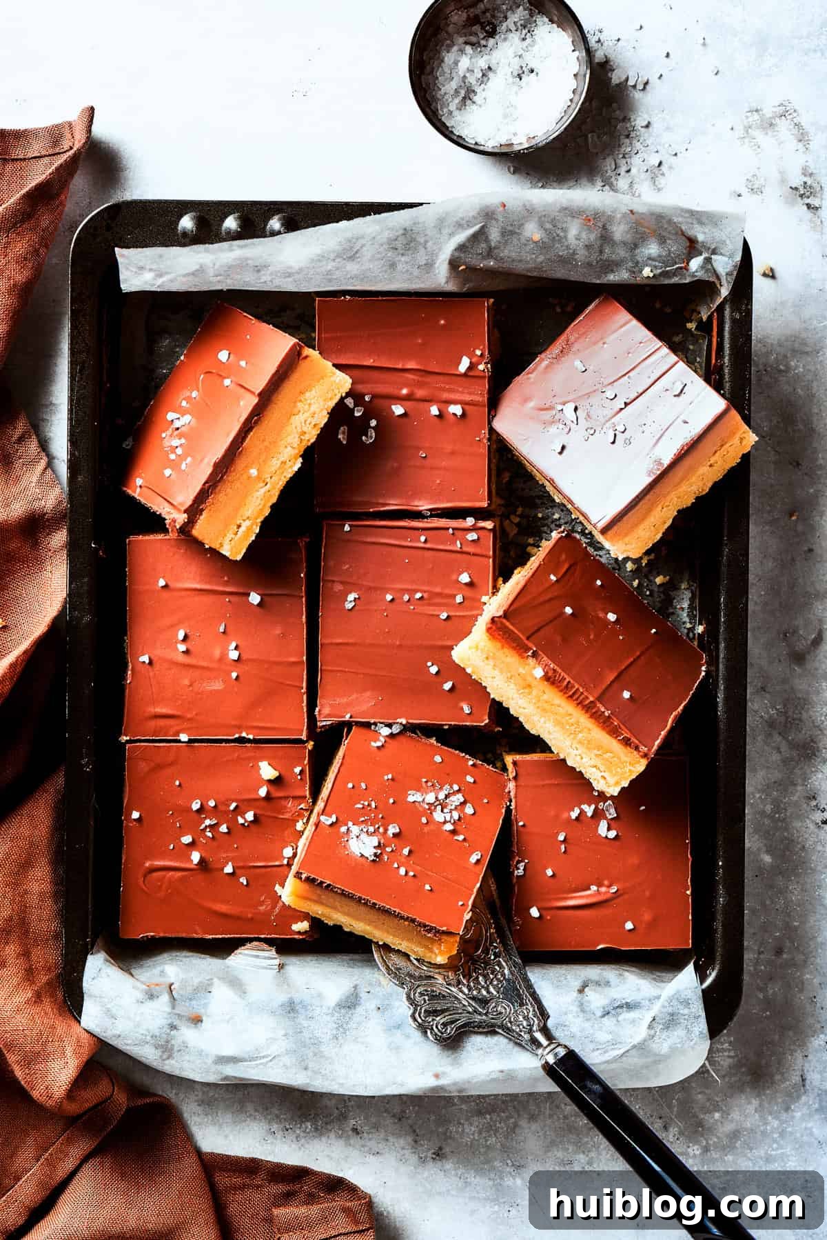 A perfectly squared pan brimming with freshly made Millionaire Bars, showcasing the even layers of shortbread, caramel, and chocolate.