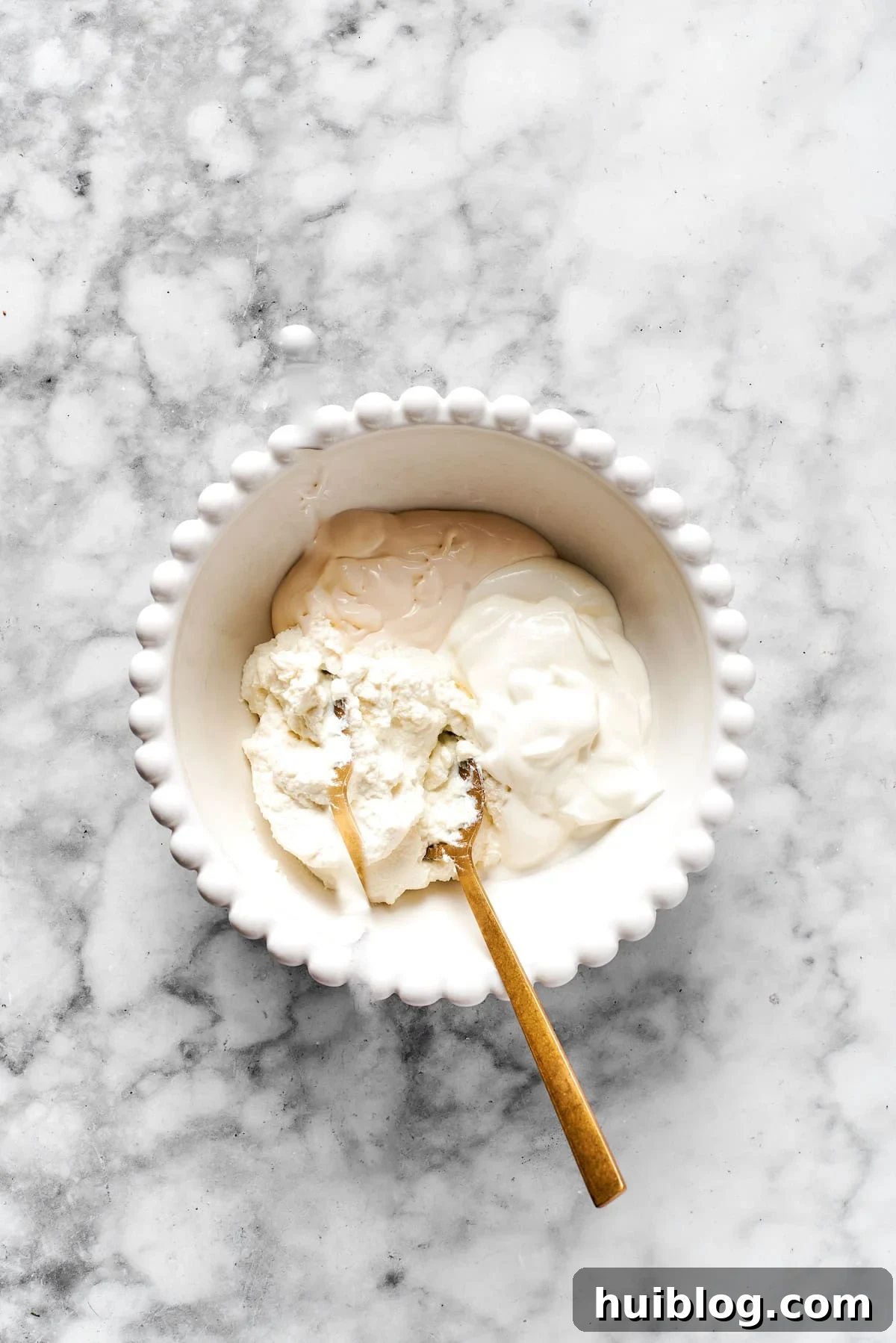 Cheese mixture ingredients added to a white bowl.