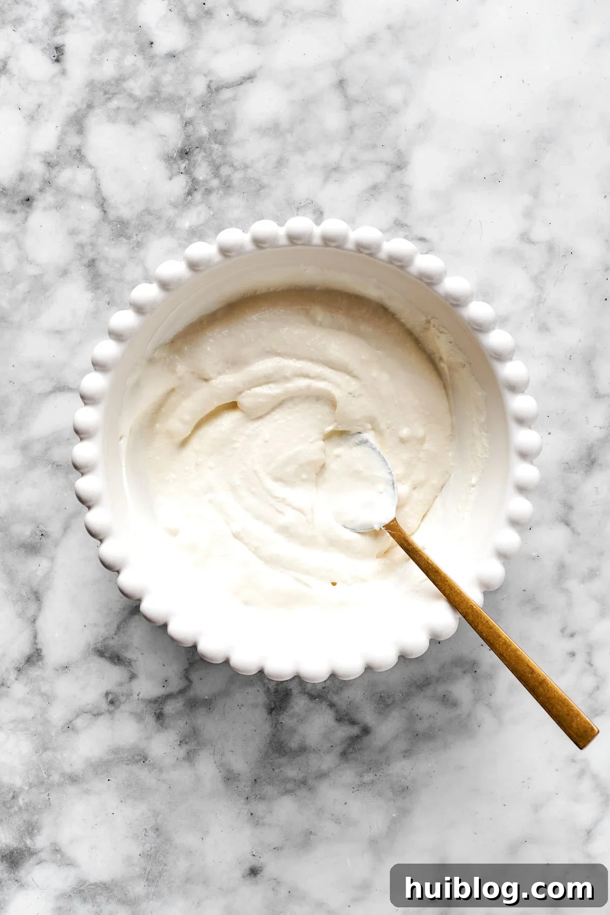Finished cheese mixture in a white bowl, smooth and creamy.