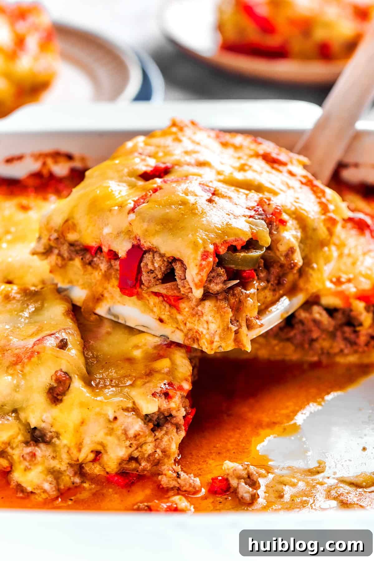 A perfectly portioned slice of John Wayne Casserole being scooped out of the dish with a serving utensil.