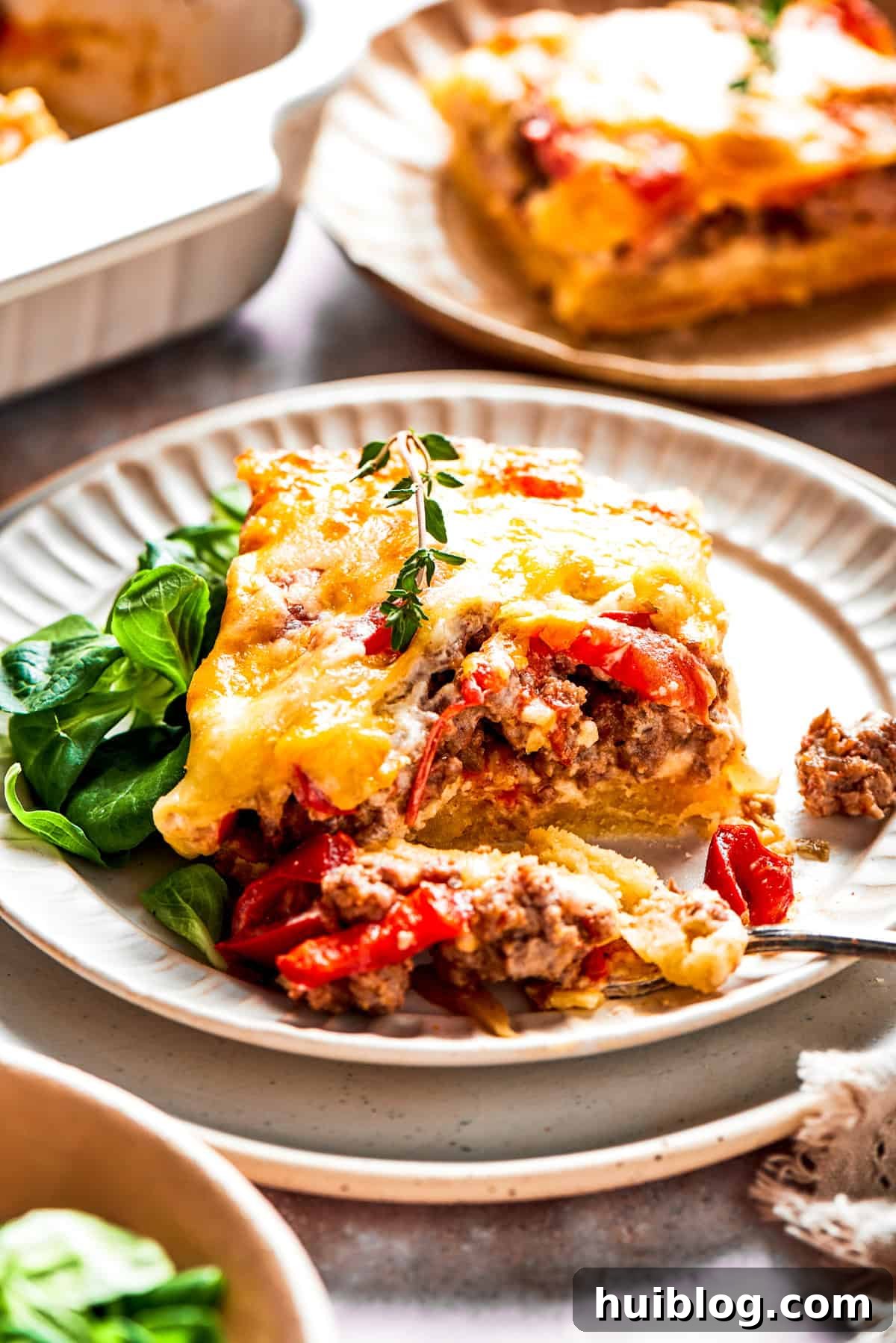 A single slice of John Wayne Casserole served on a white dinner plate, garnished slightly.