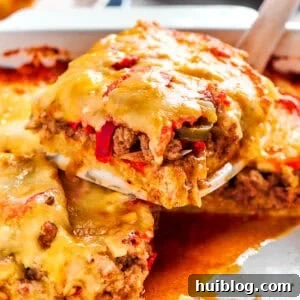 A slice of John Wayne Casserole getting scooped out of a casserole dish.
