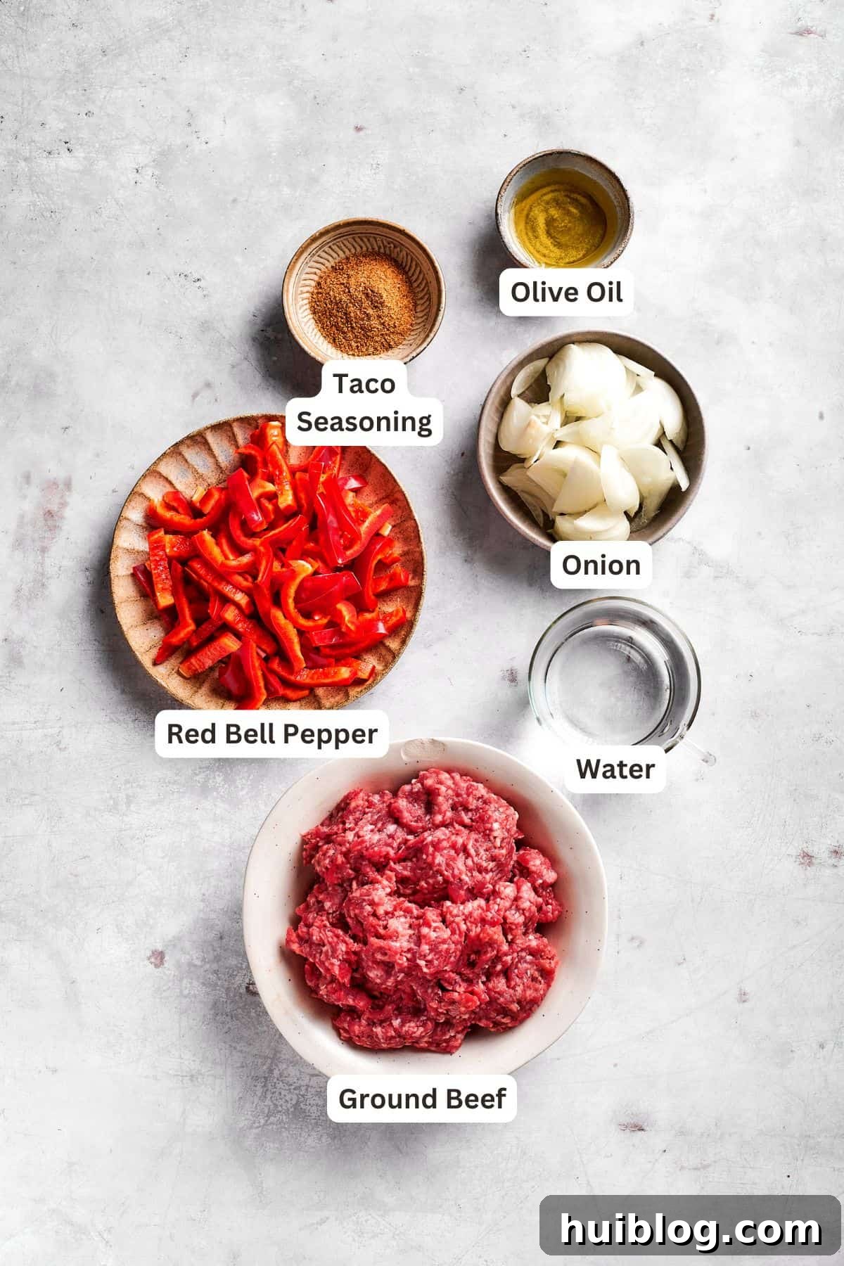 Various ingredients for John Wayne Casserole arranged in small bowls, ready for preparation.