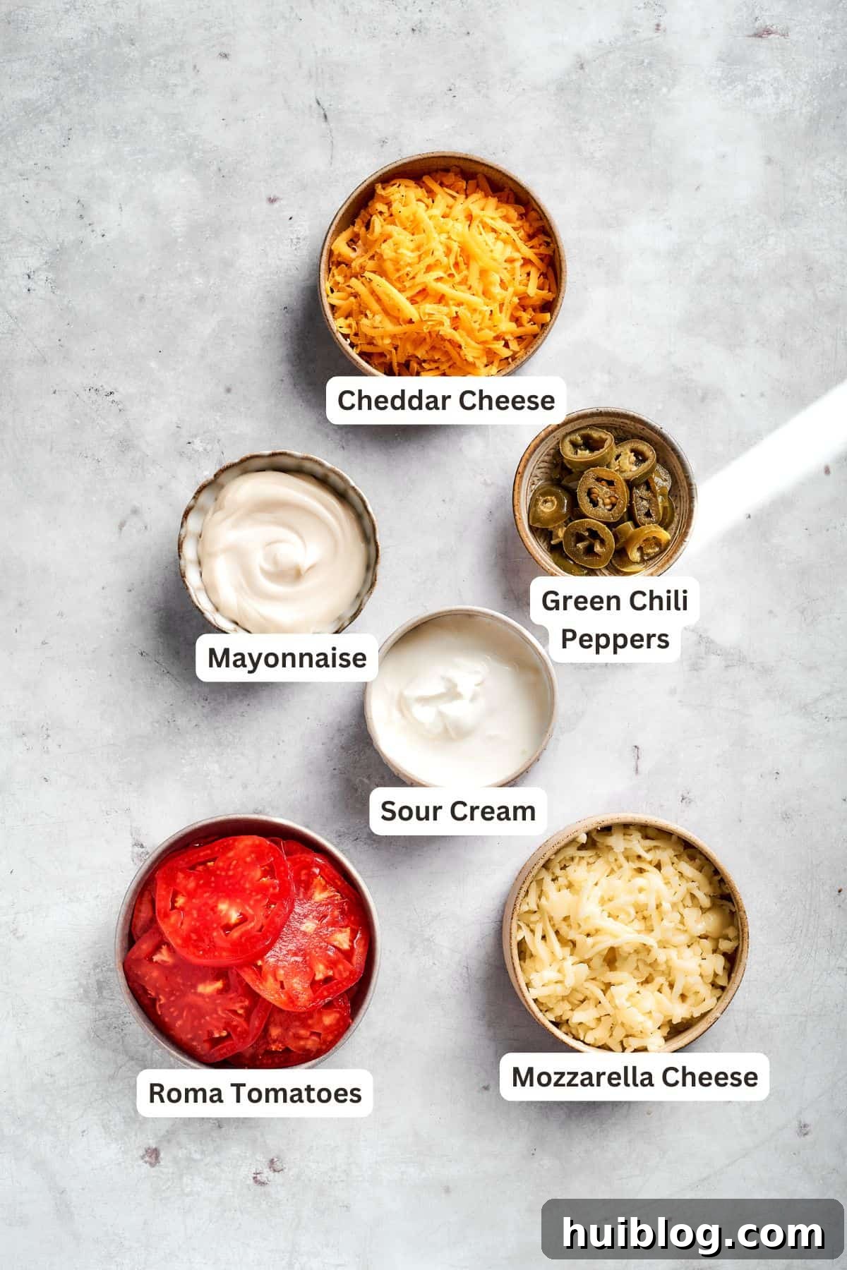 More ingredients for John Wayne Casserole, including cheeses and canned goods, laid out for cooking.