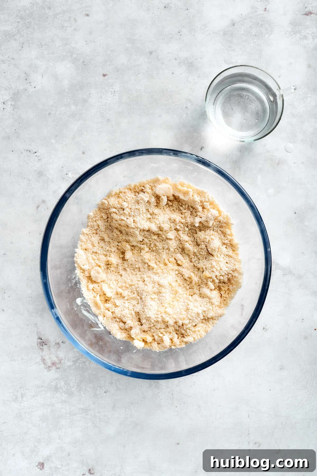 Mixing Bisquick and water in a glass bowl to form the dough.