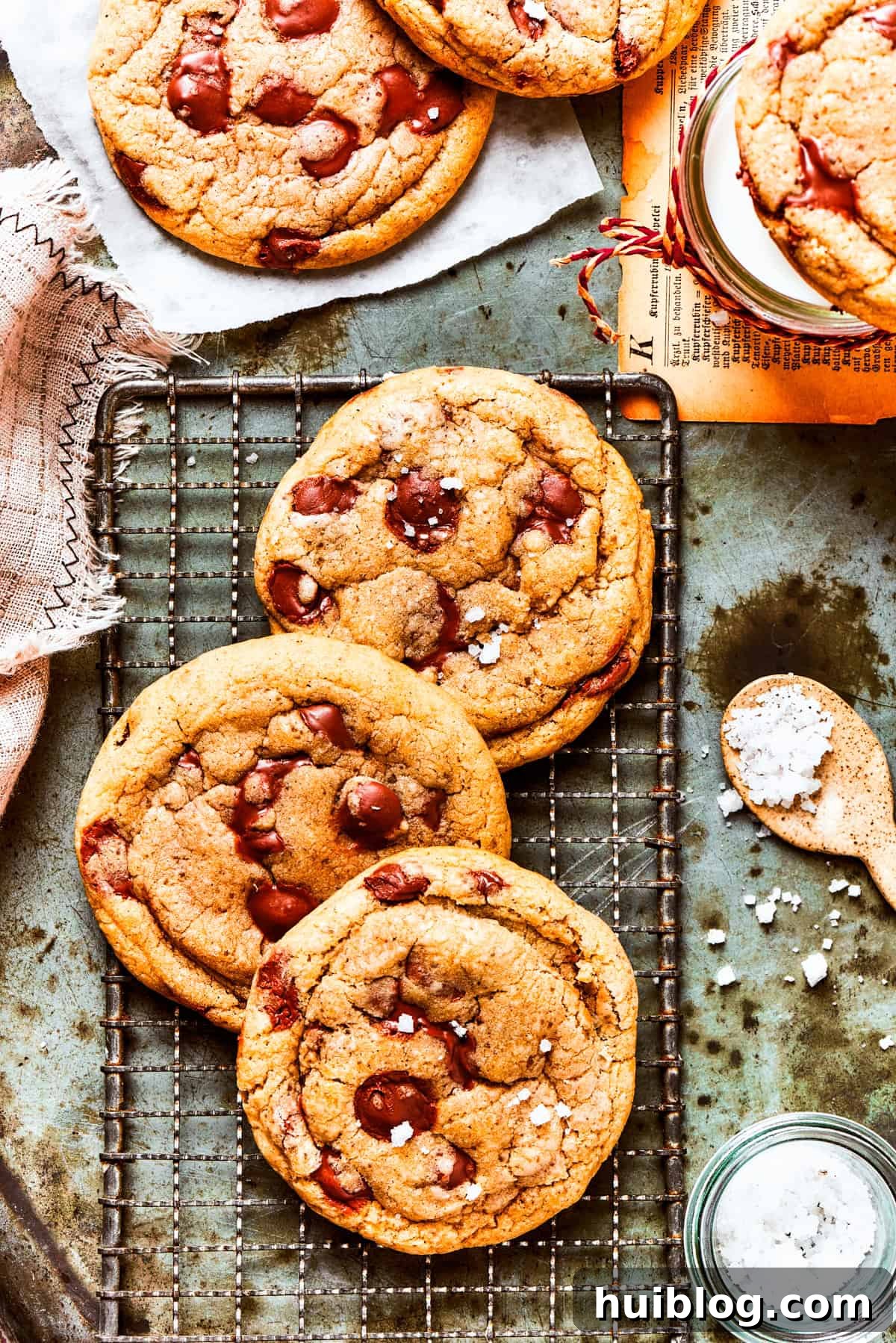 Three perfectly baked Brown Butter Chocolate Chip Cookies cooling on a wire rack, showcasing their golden-brown edges and soft centers.