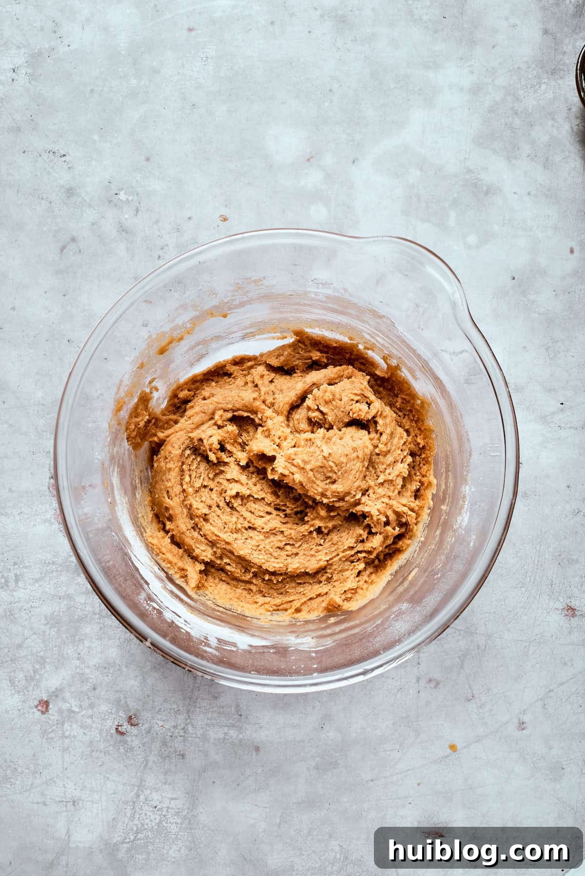 A close-up of the perfectly mixed cookie dough in a bowl, showcasing its smooth, consistent texture before adding chocolate.