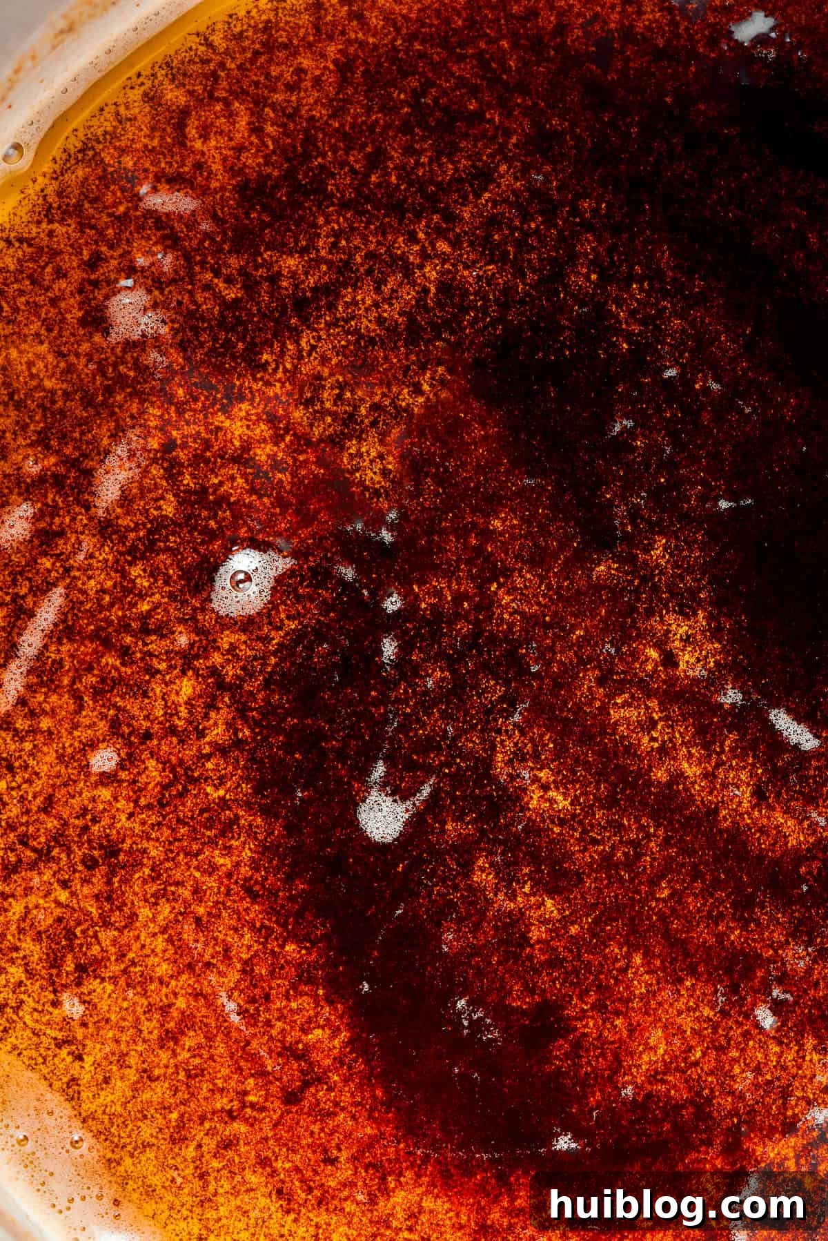 A close-up view of deeply toasted, golden-brown butter with visible caramelized milk solids at the bottom of a pan, illustrating the perfect browning.
