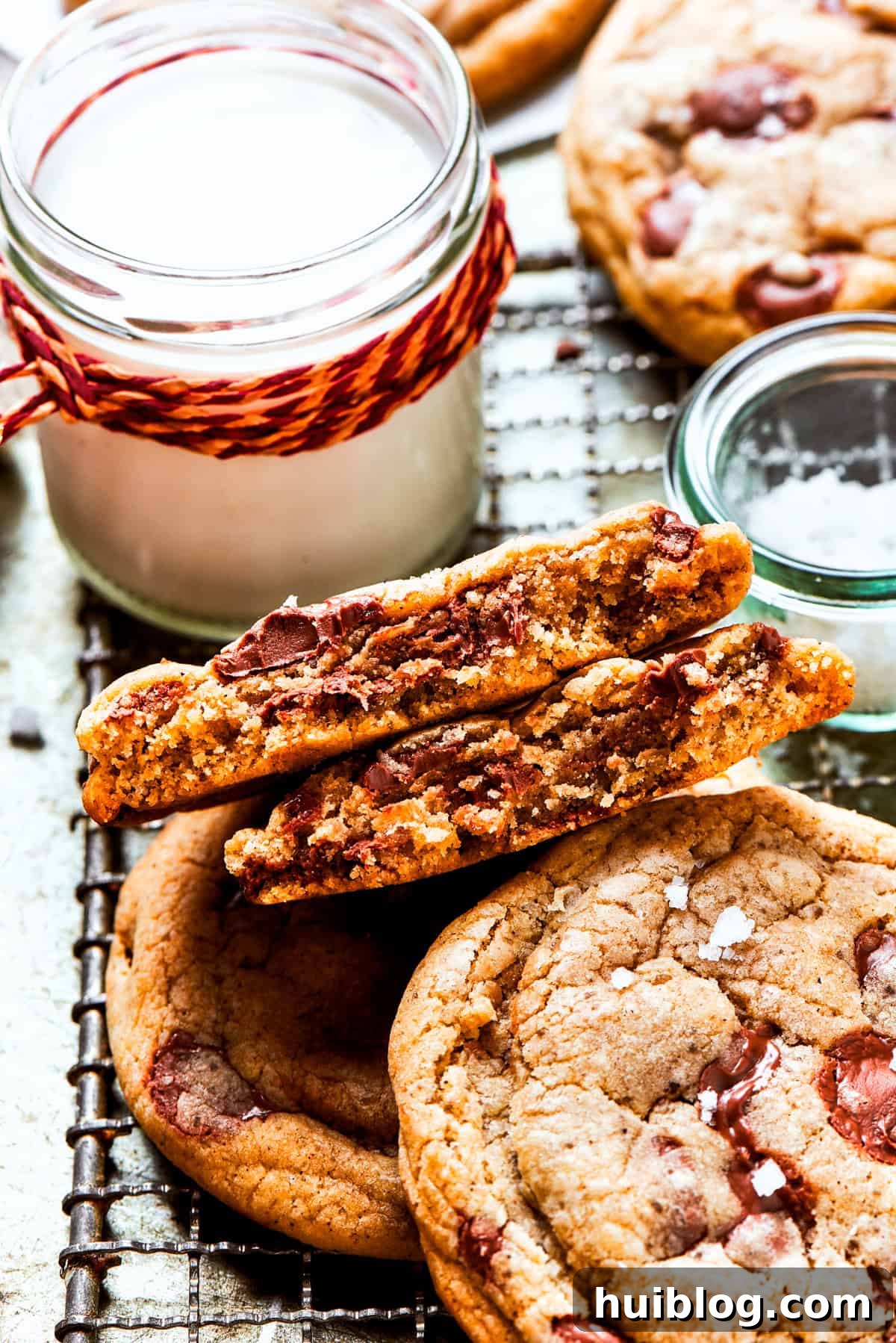 Freshly baked Brown Butter Chocolate Chip Cookies cooling on a wire rack, with a rustic jug of milk nearby, inviting a delightful pairing.
