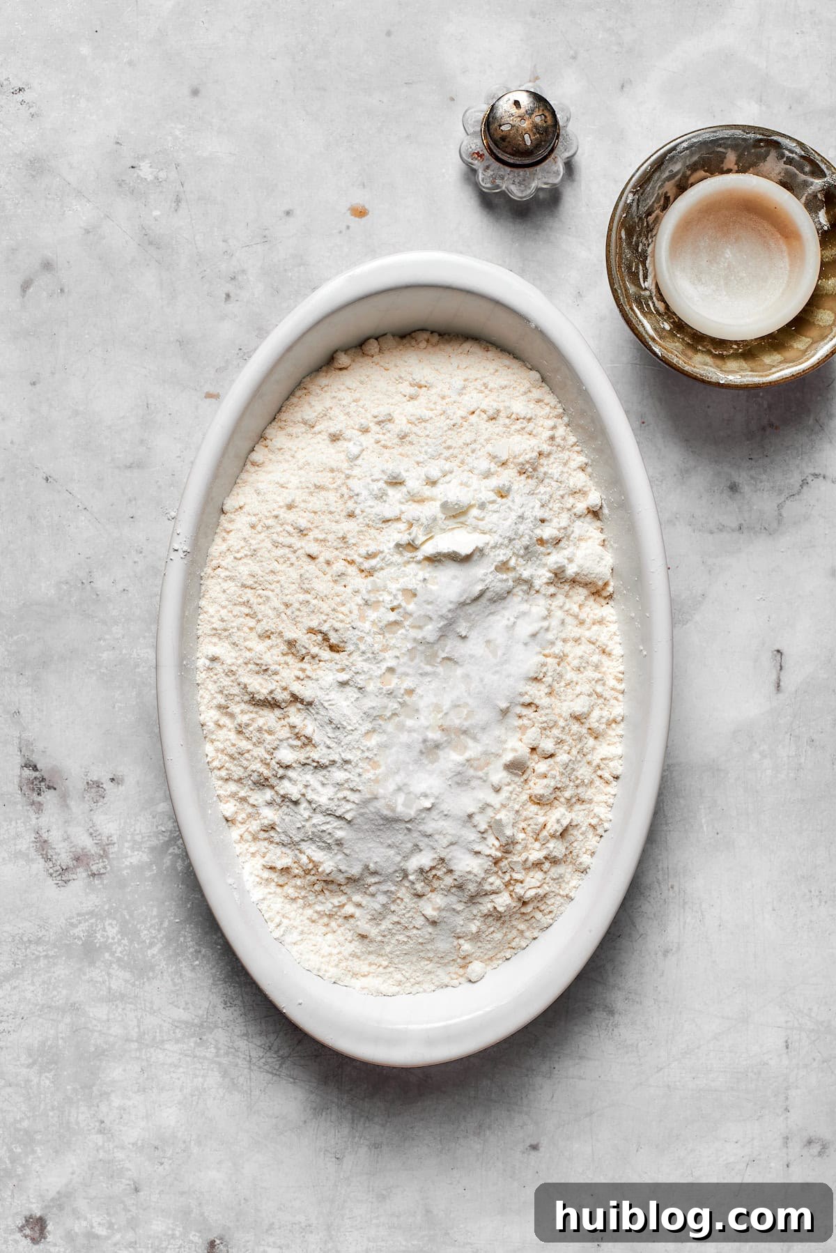 A bowl containing a precise blend of dry ingredients – flour, cornstarch, baking soda, and salt – for the cookie recipe.