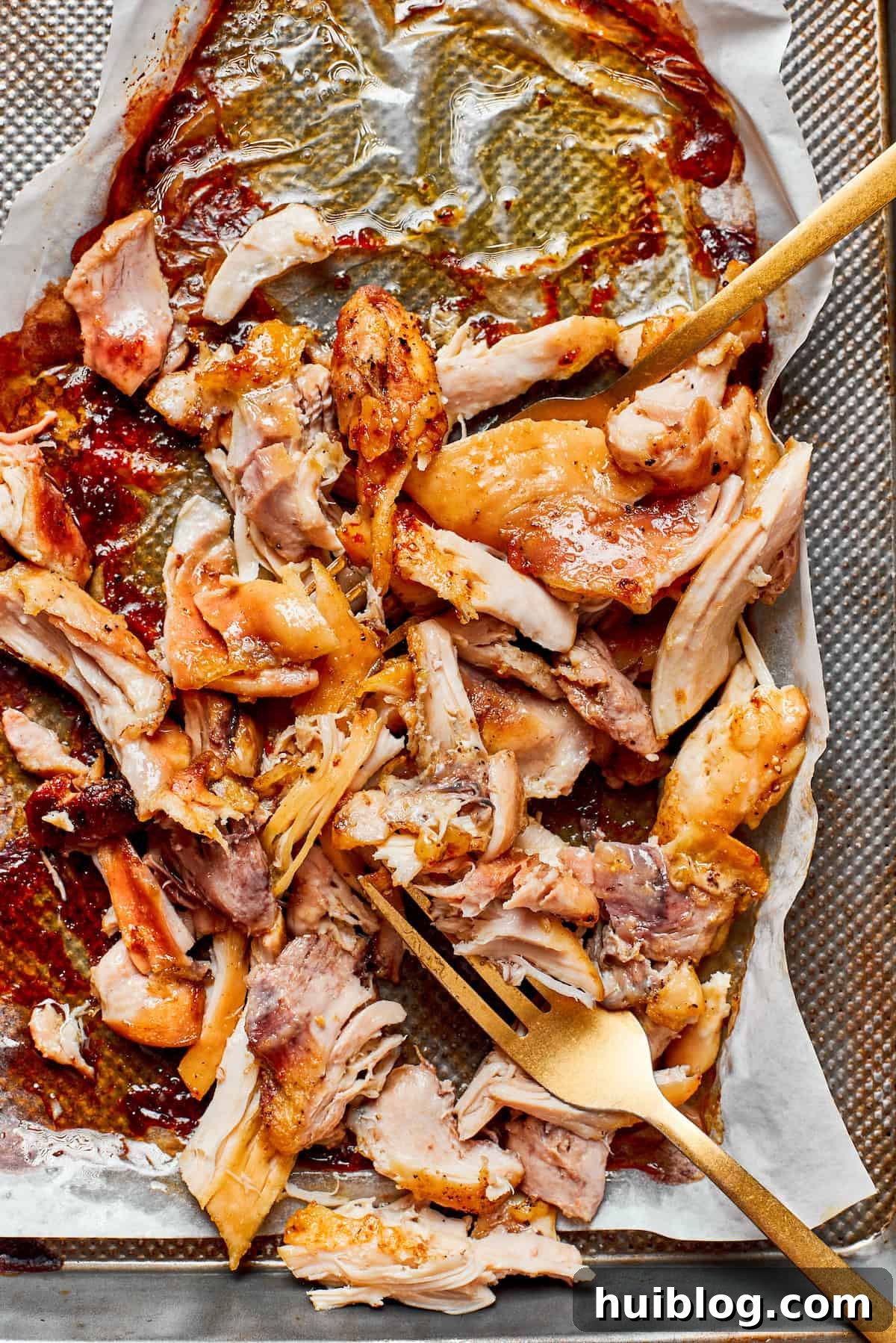 Cool, then shred. A pile of perfectly cooked and shredded chicken on a cutting board, ready to be added to the creamy pasta sauce.