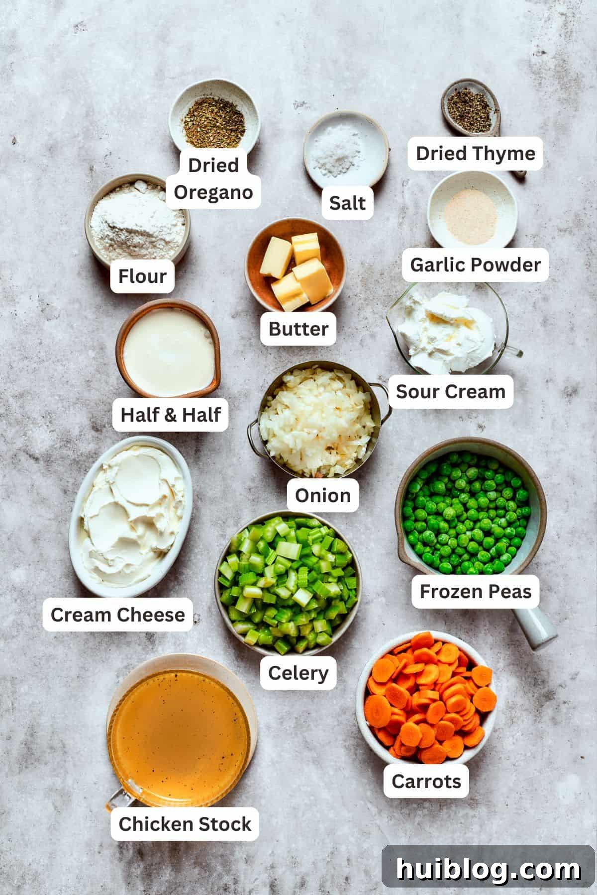 Fresh Ingredients for Creamy Pot Pie Filling A collection of fresh ingredients laid out for making the chicken pot pie filling, including chicken, carrots, celery, onion, and various seasonings.