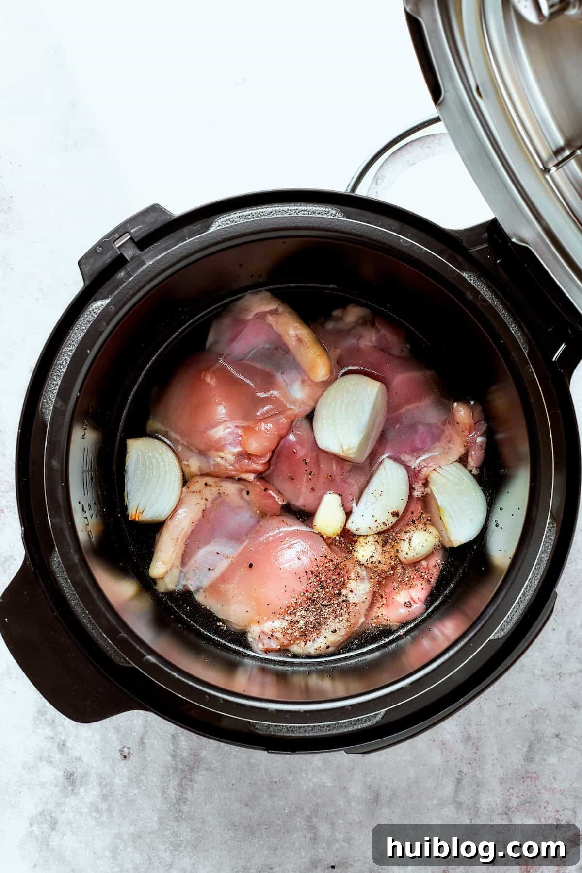 Hearty Chicken Pot Pie Casserole 2 Chicken, onion, garlic, salt, pepper, and water added to an Instant Pot.