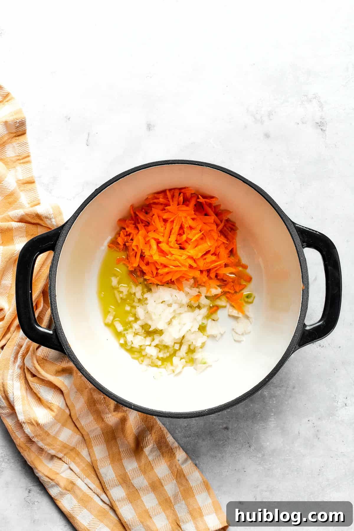 Cooking carrots and onion in a large pot, sizzling gently in olive oil.