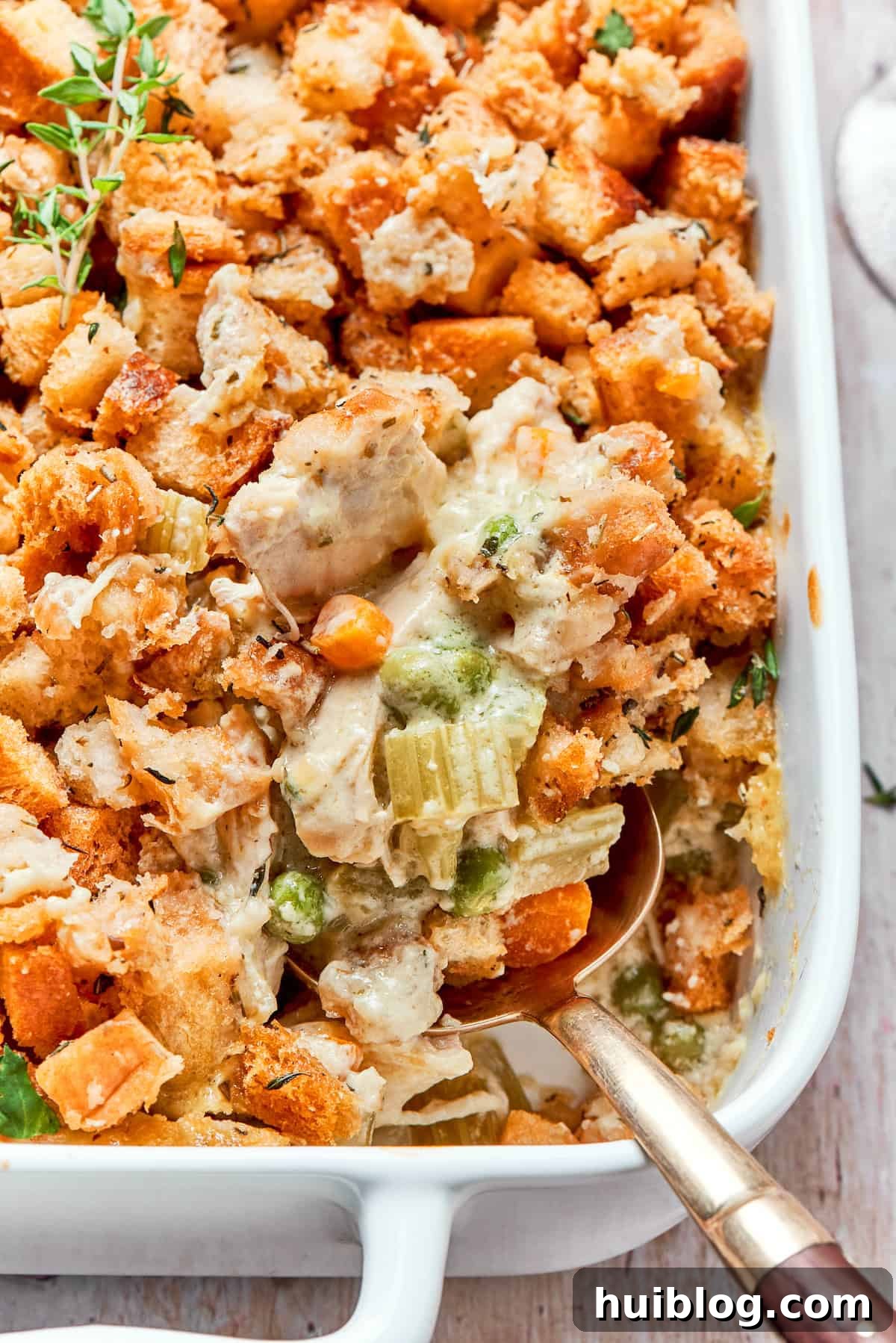 This chicken stuffing casserole features tender chicken filling with veggies topped with classic stuffing. An easy recipe baked until golden! Golden brown chicken stuffing casserole in a large baking dish, ready to be served.