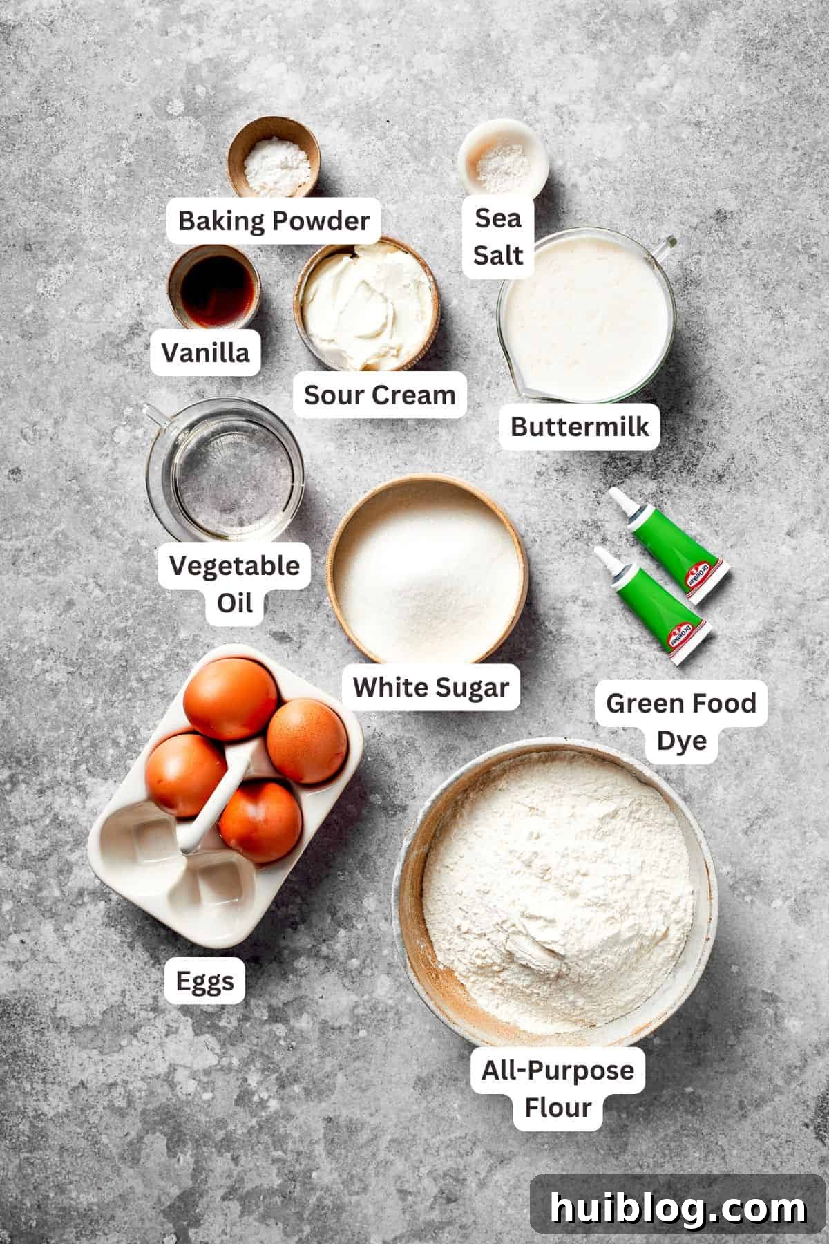 Ingredients to make a grinch cake are text labeled, showing flour, sugar, eggs, oil, and buttermilk.