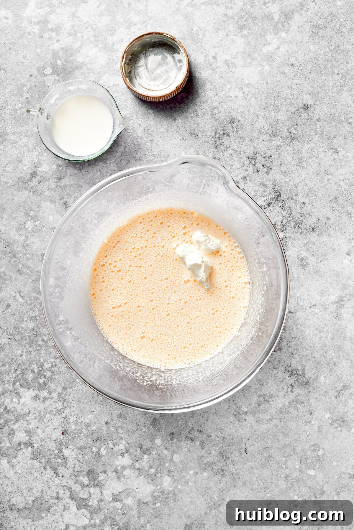 Sour cream being added to the cake batter mixture.