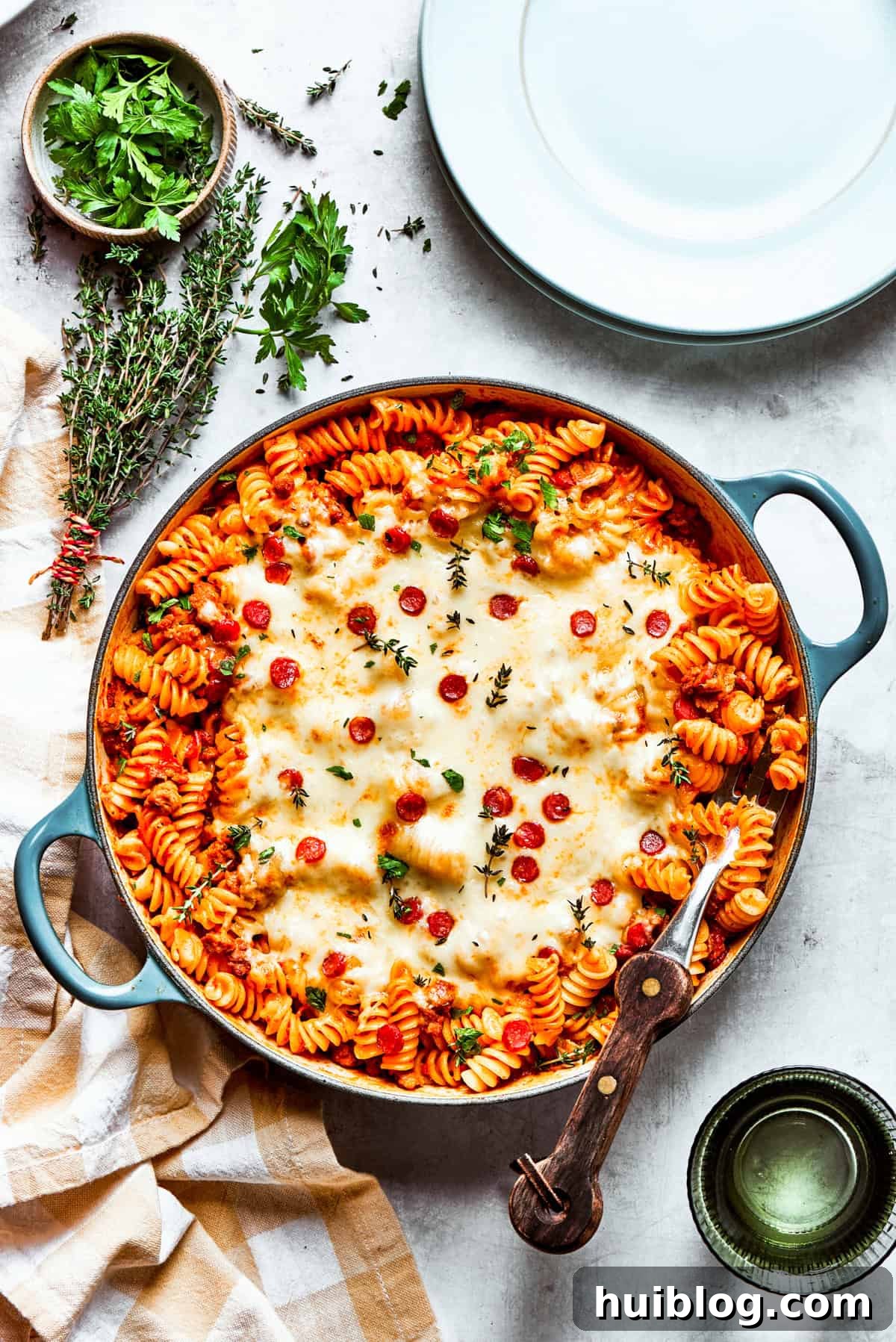 A wide shot of a delicious pan of pizza pasta, freshly made and topped with melted cheese and pepperoni, ready for serving.