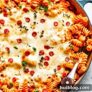 A big pan of pizza pasta topped with melted cheese and pepperoni.
