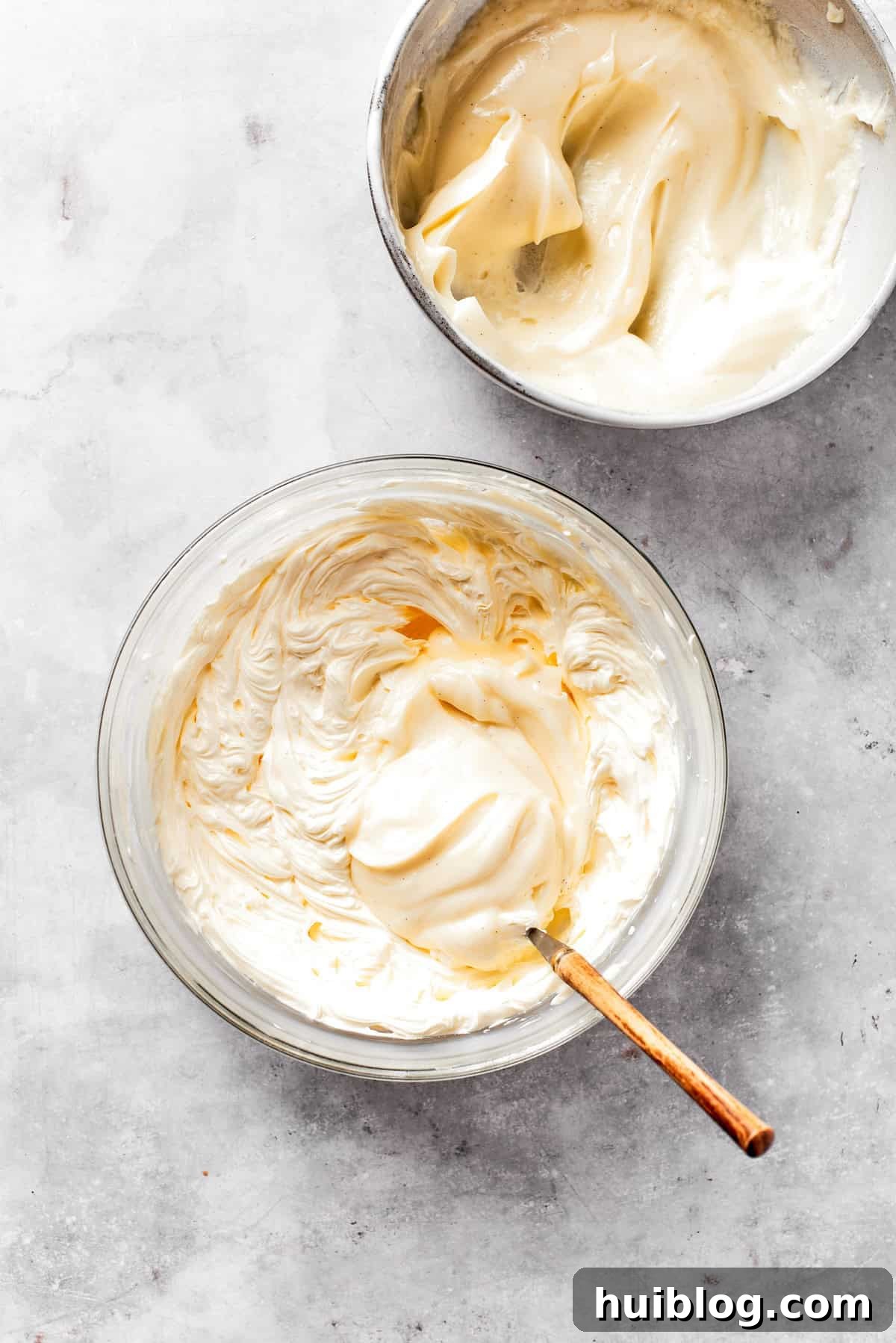 Cream cheese frosting is mixed in a bowl.