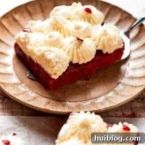 A red velvet brownie with frosting on a plate.