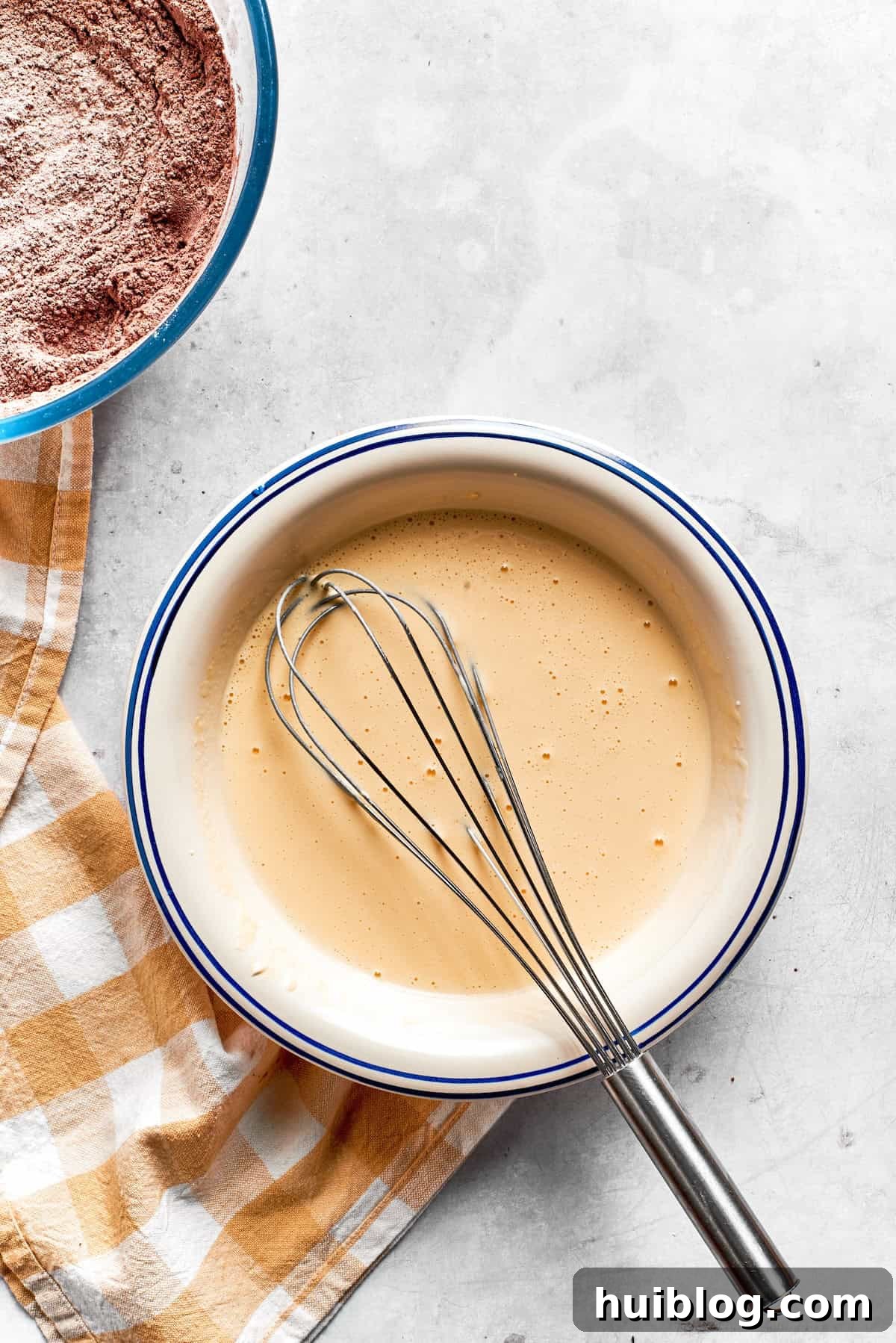 The smooth wet mixture for chocolate muffins in a bowl, ready to be combined.