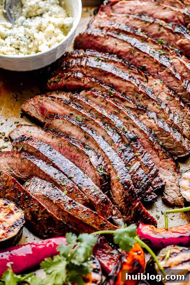 side close up shot of sliced grilled flank steak with a white bowl next to it