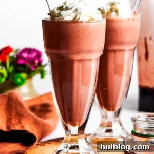 Chocolate milkshakes topped with whipped cream.