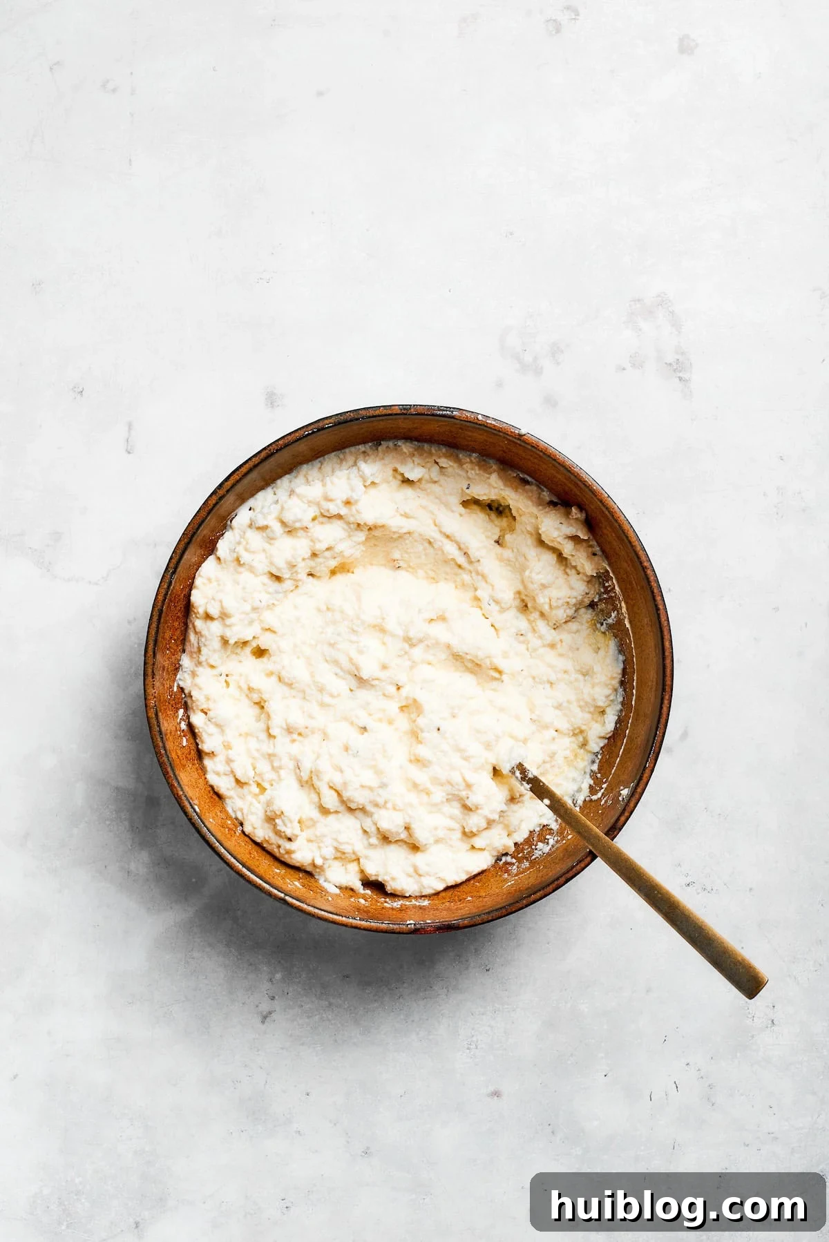 A bowl of rich, creamy ricotta cheese mixture, perfectly blended and seasoned for layering in lasagna.