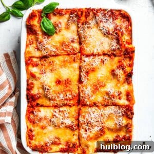 A pan of beef lasagna cut into squares.