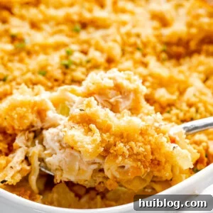 scooping out tuna noodle casserole from baking dish