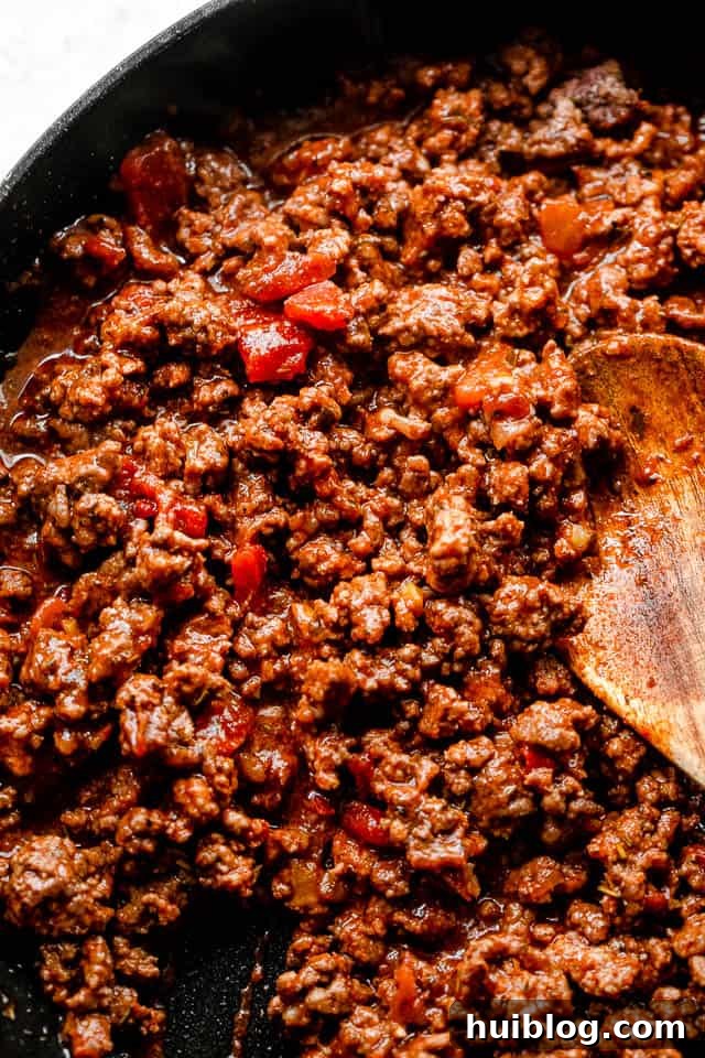 Stuffed pasta shells with a savory beef and ricotta filling, baked in marinara and topped with melted cheese. It’s like lasagna in shells! top shot of cooking ground beef in a black skillet