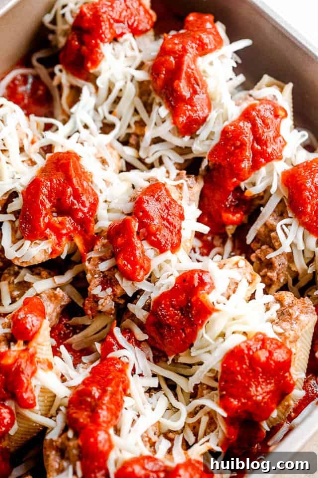Stuffed pasta shells with a savory beef and ricotta filling, baked in marinara and topped with melted cheese. It’s like lasagna in shells! preparing lasagna stuffed pasta shells for baking