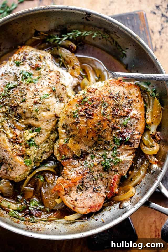 overhead shot of beautifully cooked pesto and feta stuffed pork chops in a cast iron skillet, ready to serve