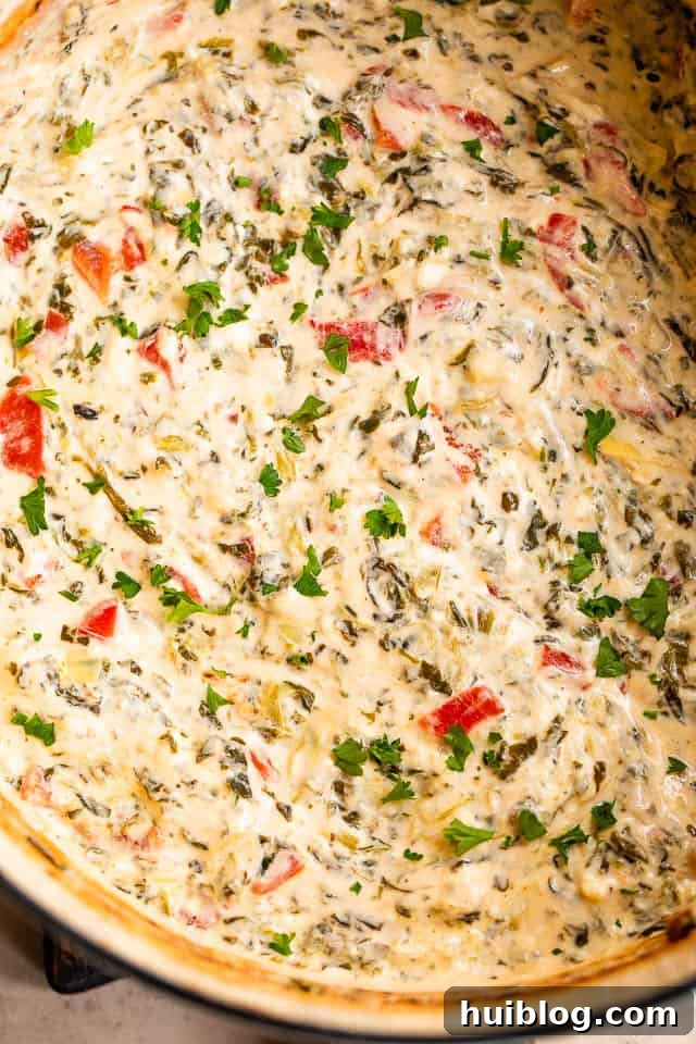 Close-up overhead shot of bubbling, cooked spinach artichoke dip in a slow cooker, ready to serve