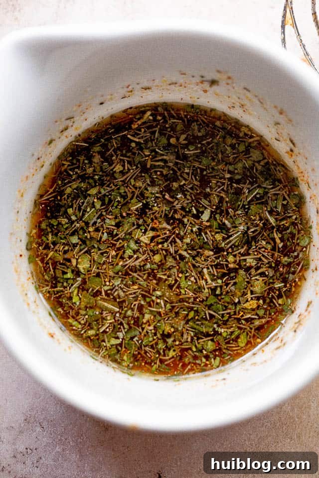 Overhead shot of a small white bowl filled with homemade balsamic vinaigrette, ready to be tossed with vegetables.