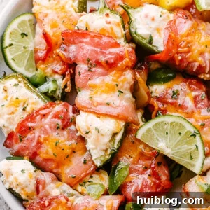 Baked Jalapeno Poppers on a serving dish, garnished with fresh herbs.