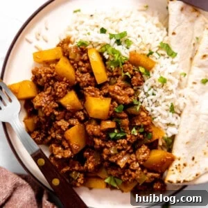Plate with rice and ground beef picadillo with a flour tortilla.