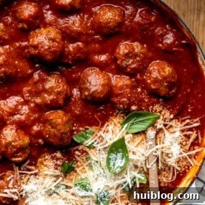 Easy homemade meatballs in a skillet with tomato sauce and topped with parmesan.