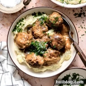 Bowl of swedish meatballs served over mashed potatoes.