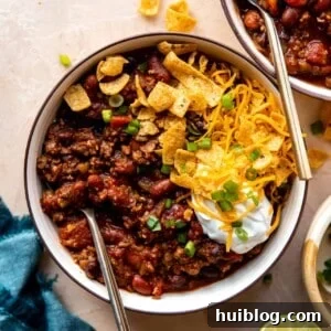 Overhead view of a bowl of chili with toppings.