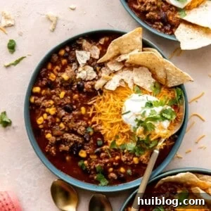 Bowl of taco soup served with cheese, sour cream and tortilla chips.