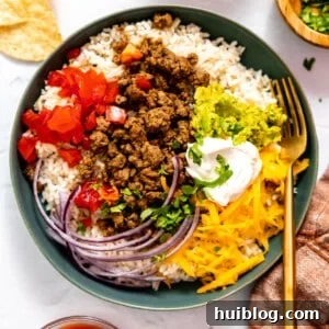 Taco bowl served over rice topped with sour cream.