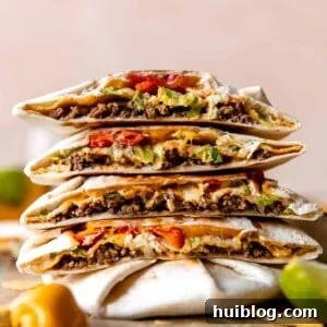 Stack of homemade Crunchwraps cut in half to show all the fillings inside.